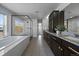 Modern bathroom features dual sinks, dark wood cabinets, granite countertops, and separate shower at 9443 Torrey Way, Arvada, CO 80007