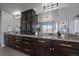 Modern bathroom features dark wood cabinets, granite countertops, dual sinks and a large mirror at 9443 Torrey Way, Arvada, CO 80007