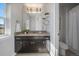 Bathroom with dark wood cabinets, granite countertops, sink, and a large mirror at 9443 Torrey Way, Arvada, CO 80007