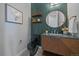 Modern powder room with designer vanity, round mirror, and stylish green tiled wall at 9443 Torrey Way, Arvada, CO 80007