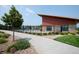 Modern community pool area with a sleek building, black metal fence, and a concrete walkway at 9443 Torrey Way, Arvada, CO 80007