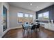 Dining area with glass table, modern chairs, and scenic backyard views from the window at 9443 Torrey Way, Arvada, CO 80007