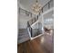 Grand foyer with staircase, iron railings, wood floors, and views into the living area at 9443 Torrey Way, Arvada, CO 80007