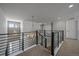 Upstairs landing with iron railing and chandelier providing views to below at 9443 Torrey Way, Arvada, CO 80007