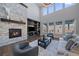 Spacious living room featuring a stone fireplace, built-in shelving, and large windows with outdoor views at 9443 Torrey Way, Arvada, CO 80007