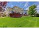 Spacious backyard with a brick retaining wall and mature lawn at 24351 E Alamo Dr, Aurora, CO 80016