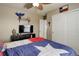 Cozy bedroom with tan walls, fan, and a Texas flag themed bedspread on the bed at 24351 E Alamo Dr, Aurora, CO 80016