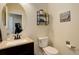 Compact powder room features a pedestal sink, round mirror, and wall-mounted shelving at 24351 E Alamo Dr, Aurora, CO 80016