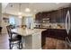 Bright kitchen with granite island, stainless appliances, dark wood cabinets, and breakfast bar at 24351 E Alamo Dr, Aurora, CO 80016