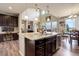 Open kitchen with granite island, stainless steel appliances, and wood floors at 24351 E Alamo Dr, Aurora, CO 80016