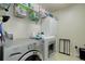 Bright laundry room featuring a front loading washer and dryer, storage cabinets and metal shelving at 24351 E Alamo Dr, Aurora, CO 80016