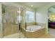 The ensuite bathroom features a glass shower and a luxurious soaking tub with window views at 24351 E Alamo Dr, Aurora, CO 80016