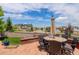 Inviting patio with an outdoor dining table, brick walls, and mature landscaping at 24351 E Alamo Dr, Aurora, CO 80016