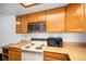 Functional kitchen featuring wood cabinetry, essential appliances, and a microwave at 15350 E Arizona Ave # 106, Aurora, CO 80017