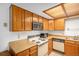 Functional kitchen with wood cabinetry, laminate countertops, and essential appliances at 15350 E Arizona Ave # 106, Aurora, CO 80017