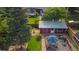 Aerial view of landscaped backyard with grass, garden, deck, red shed, and mature trees at 1648 S Locust St, Denver, CO 80224