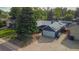 Aerial view of a home with solar panels and mature landscaping, large driveway and an attached garage at 1648 S Locust St, Denver, CO 80224