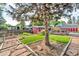 Landscaped backyard featuring a patio, garden beds, mature trees, and green grass at 1648 S Locust St, Denver, CO 80224
