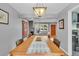 Dining room with a long table, chandelier, gray walls and access to the kitchen at 1648 S Locust St, Denver, CO 80224