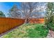 Backyard with a wooden fence, green grass, and a large tree providing shade at 9109 Ironwood Way, Highlands Ranch, CO 80129