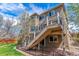 A charming backyard featuring a multi-level deck with a wooden staircase, perfect for outdoor entertaining and relaxation at 9109 Ironwood Way, Highlands Ranch, CO 80129