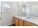 Bathroom featuring double sinks, wood cabinets, and a large mirror at 9109 Ironwood Way, Highlands Ranch, CO 80129