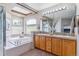 Luxurious bathroom with dual sinks, garden tub, and contemporary lighting at 9109 Ironwood Way, Highlands Ranch, CO 80129