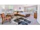 Bright bedroom with wooden bed frame, cowhide rug, and colorful chairs under natural lighting at 9109 Ironwood Way, Highlands Ranch, CO 80129