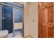 Tidy bathroom featuring a blue tiled shower with a sliding door and a wood paneled door at 900 Poplar Ave, Boulder, CO 80304