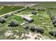Aerial view showcasing a brown home and large shop, complemented by lush green landscape and clear skies at 68251 E 96Th Ave, Byers, CO 80103