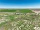 Wide aerial perspective of the land, featuring a home and shop, surrounded by green fields and meadows at 68251 E 96Th Ave, Byers, CO 80103