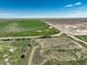 Vast aerial capture of land including farm fields, featuring a distant home and shop surrounded by nature at 68251 E 96Th Ave, Byers, CO 80103