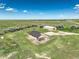 Expansive aerial view of a tan home and large shop, surrounded by green fields under a blue sky at 68251 E 96Th Ave, Byers, CO 80103