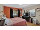 Bedroom featuring a window and orange accent wall, furnished with a cozy bed and dark dresser at 68251 E 96Th Ave, Byers, CO 80103