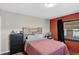 Bedroom with a red accent wall, queen bed, and dresser at 68251 E 96Th Ave, Byers, CO 80103