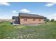 This exterior of the home shows the shingled roof and a sliding glass door at 68251 E 96Th Ave, Byers, CO 80103