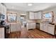 Bright kitchen featuring white cabinetry, laminate countertops, and stainless steel dishwasher at 68251 E 96Th Ave, Byers, CO 80103