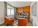 Home office featuring an orange accent wall, built-in shelves, and two orange armchairs at 2257 Base St, Fort Lupton, CO 80621