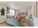 Living room with gray sofas, large windows, and wood floors at 2257 Base St, Fort Lupton, CO 80621