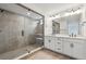 Modern bathroom featuring a glass-enclosed shower, dual vanity, and neutral tile at 9243 Truckee Ct, Commerce City, CO 80022