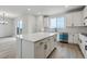 Well-appointed kitchen with island, modern appliances, white cabinetry, and adjacent living space at 9243 Truckee Ct, Commerce City, CO 80022
