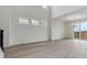 Sun-drenched living room featuring high ceilings, light wood flooring, and access to the outdoors at 9243 Truckee Ct, Commerce City, CO 80022
