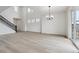 Bright, open living room with light wood floors, tall ceilings, and modern chandelier at 9243 Truckee Ct, Commerce City, CO 80022