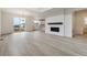 Bright, open-concept living room with fireplace, light wood floors, and seamless flow to the kitchen at 9243 Truckee Ct, Commerce City, CO 80022