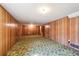 Large basement area featuring wood paneling and carpeted floors, with plenty of potential for customization at 392 Central Ave, Brighton, CO 80601