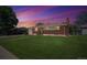 Charming brick home with a well-maintained lawn, mature trees, and inviting curb appeal at 392 Central Ave, Brighton, CO 80601
