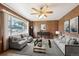 Cozy living room featuring wood paneling, neutral furniture, and a bright window view at 392 Central Ave, Brighton, CO 80601