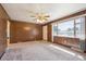 Spacious living room featuring wood paneling, neutral carpet, and a bright window at 392 Central Ave, Brighton, CO 80601