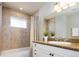 Bathroom with tub and tiled shower area, granite counters, and modern vanity at 2978 Osceola St, Denver, CO 80212