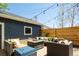 Outdoor patio with lounge chairs and pillows surrounding fire pit with a wood fence at 2978 Osceola St, Denver, CO 80212